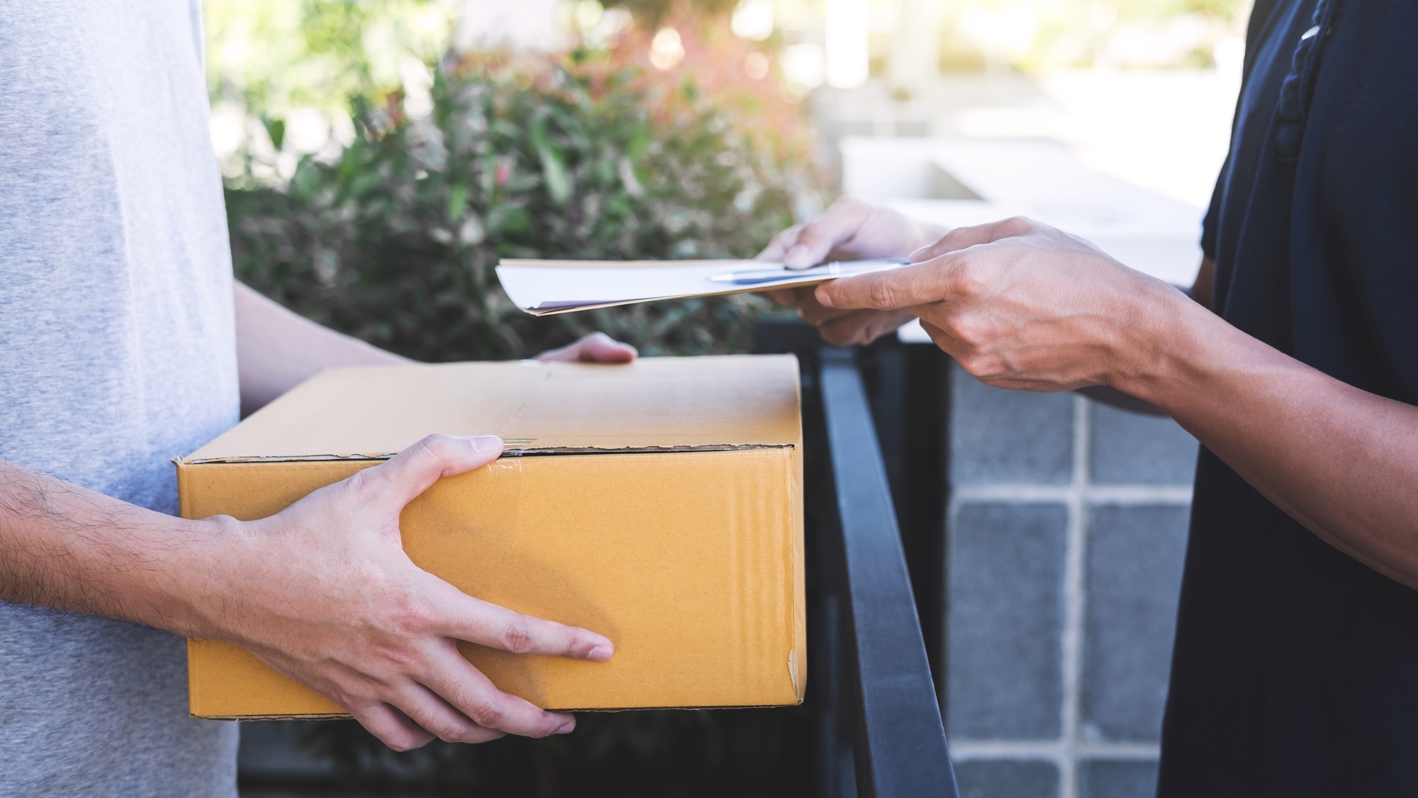 Delivery mail man giving parcel box to recipient